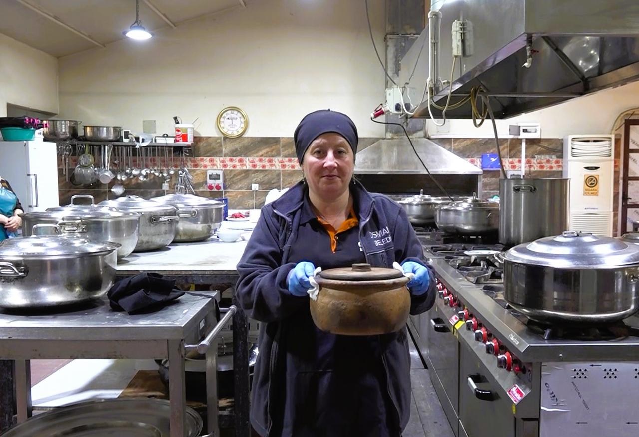 A restaurant worker holds a traditional clay pot used in the preparation of papaz yahnisi, reflecting the continued use of traditional cookware in the dish’s preparation. (AA Photo)