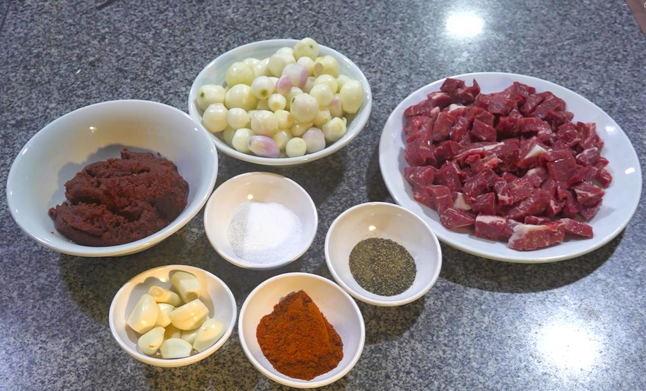 The main ingredients of papaz yahnisi, including beef, pearl onions, garlic, spices, and tomato paste, are arranged before cooking. (AA Photo)