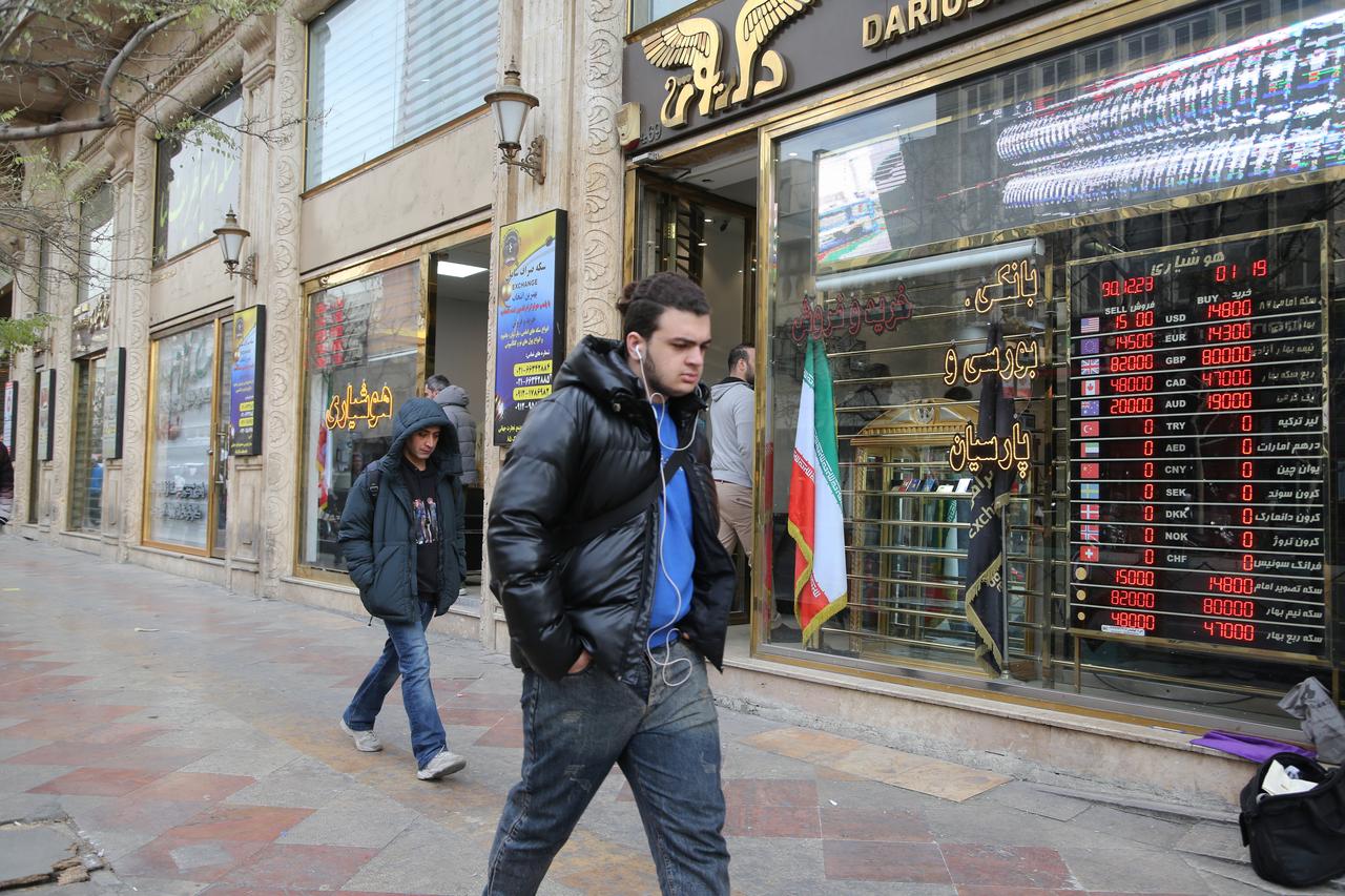 People walk past currency exchange offices on Ferdowsi Street as the offices have not yet returned to normal operations in Tehran, Iran on Jan. 15, 2026. (AA Photo)