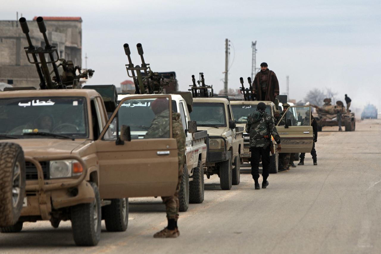 Syrian army soldiers, along with their armoured vehicles, gather as they prepare to enter the town of Deir Hafir on January 17, 2026. (AFP Photo)