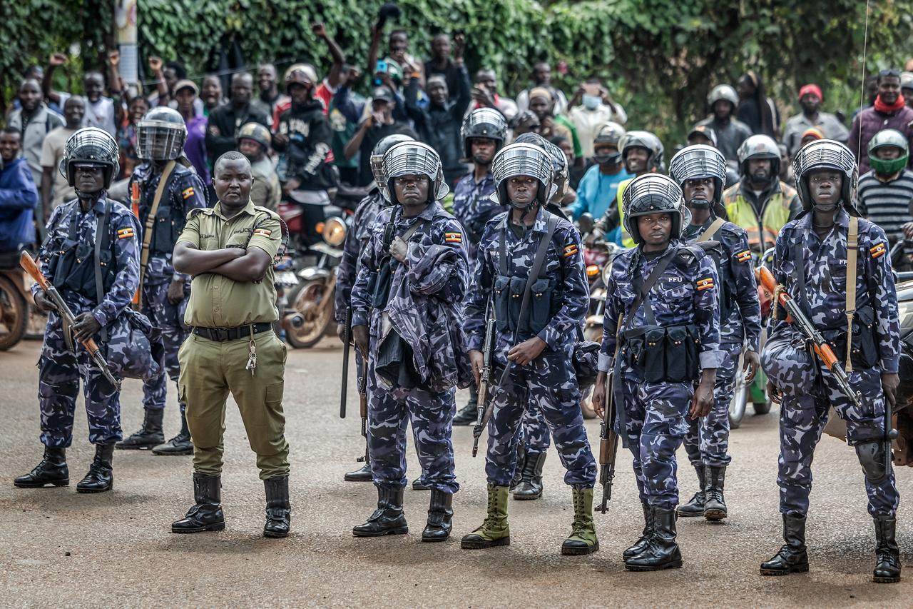 Members of the Uganda Police Force monitor the area as supporters of opposition leader and presidential candidate for the National Unity Platform (NUP) Robert Kyagulanyi Ssentamu, popularly known as Bobi Wine, gather to see his convoy on the way to the party’s final campaign rally ahead of the 2026 general elections, in Kampala on Jan. 12, 2026. (AFP Photo)