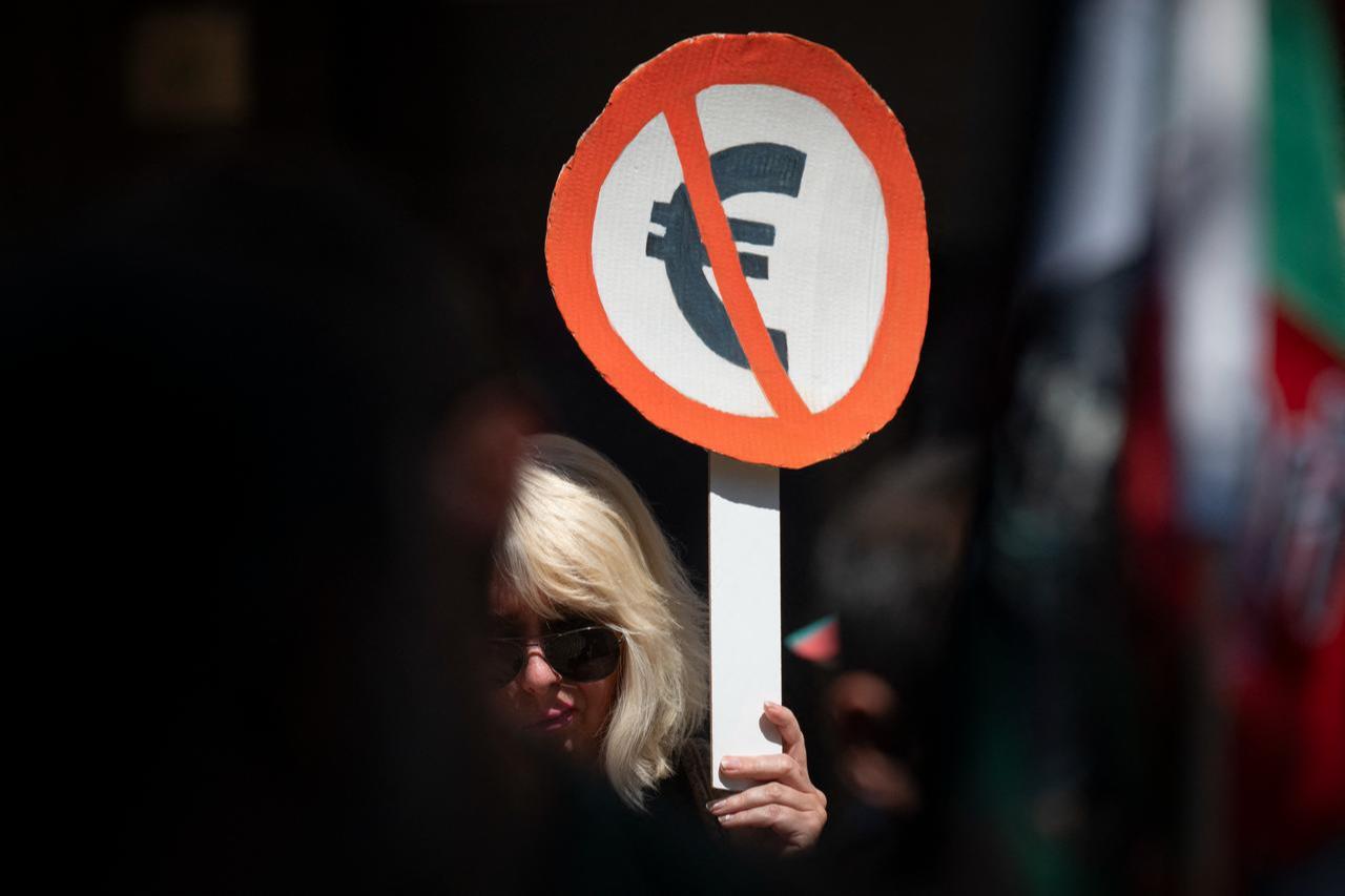 A woman holds a placard with the symbol of Euro during a demonstration against Bulgaria entering the Eurozone in Sofia on June 4, 2025. (AFP File Photo)
