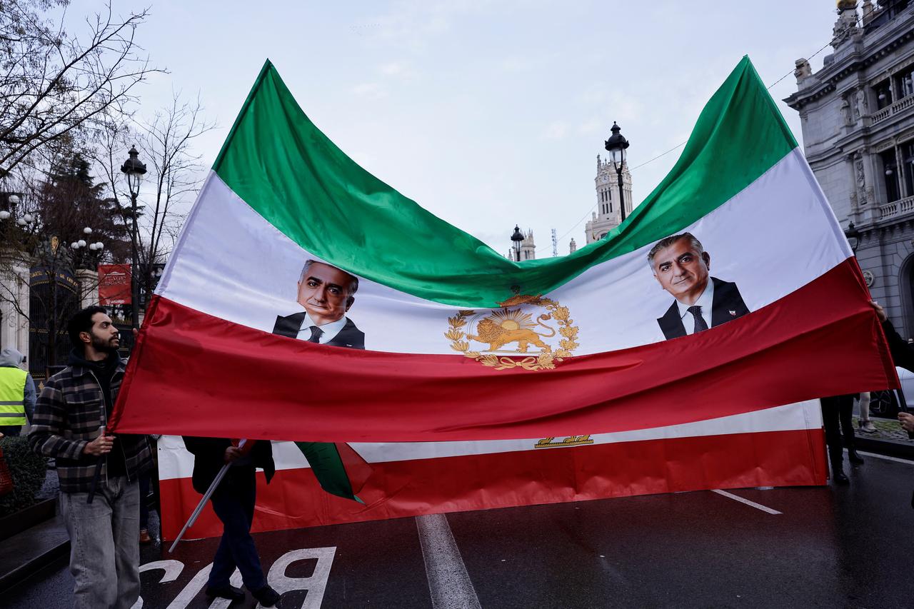 Protestors hold an Iranian flag, from the time before the 1979 revolution, with the Lion and Sun emblem, and portraits of the son of the last shah of Iran Mohammad Reza Pahlavi, Reza Pahlavi, during a demonstration in support of Iranian People in Madrid, Jan. 17, 2026. (AFP Photo)