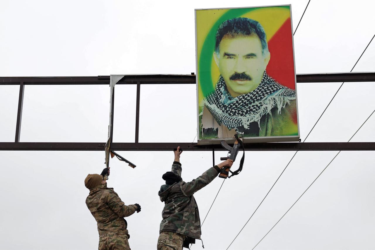Syrian army personnel prepare to tear-off a portrait of jailed PKK ringleader Abdullah Ocalan installed along a street in Tabqa, in Raqqa province, Syria, January 18, 2026. (AFP Photo)