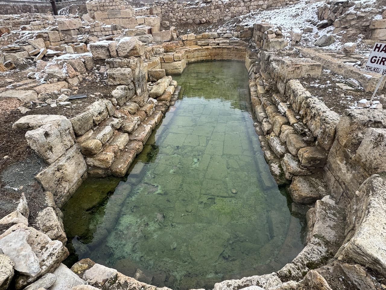 Steam rises from the naturally heated water in a narrow stone-lined pool at the Basilica Therma Roman Bath, also known as the Kral Kizi, in the Sarikaya district of Yozgat, central Türkiye, during winter conditions. (AA Photo)