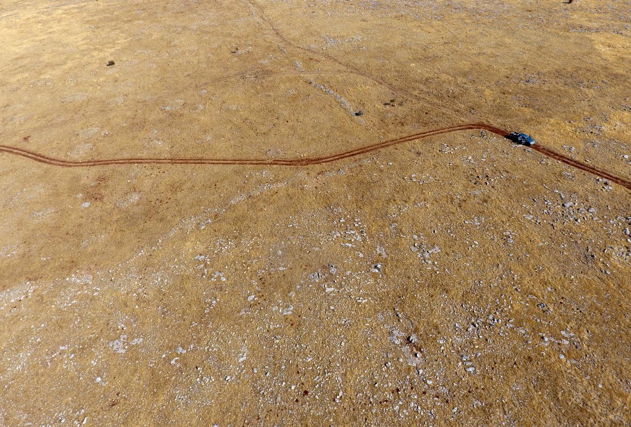 An aerial view shows vehicle tracks across an open landscape as researchers carry out long-distance walking surveys to trace ancient human activity in Gaziantep, Türkiye, Jan. 2025. (AA Photo)