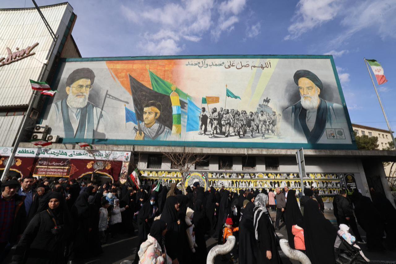 People walk past a banner depicting Iran’s Supreme Leader Ali Khamenei and late leader Ruhollah Khomeini on Enghelab (Revolution) Square in Tehran on January 14, 2026. (AFP Photo)