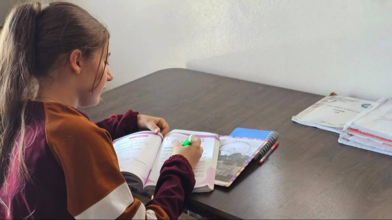 High school student Sima Ahmed, 16, does her homework in Kurdish at her home in Syria’s northeastern Qamishli city, May 15, 2025. (Photo via Syria Direct)