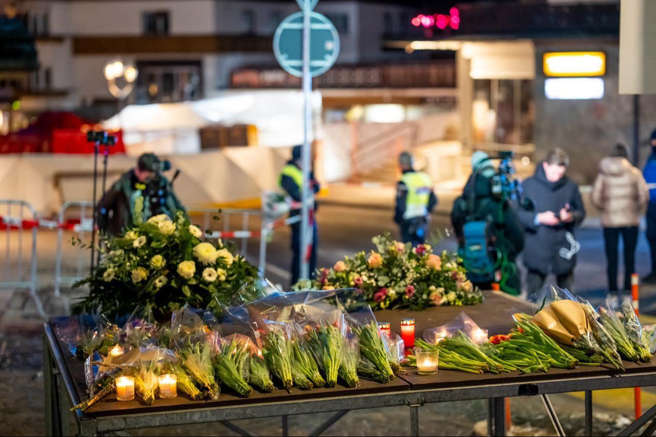 This photograph shows flowers and candles laid near the site where a fire ripped through a crowded bar during New Year's Eve celebrations in the Alpine ski resort town of Crans-Montana, Jan. 1, 2026. (AFP Photo)