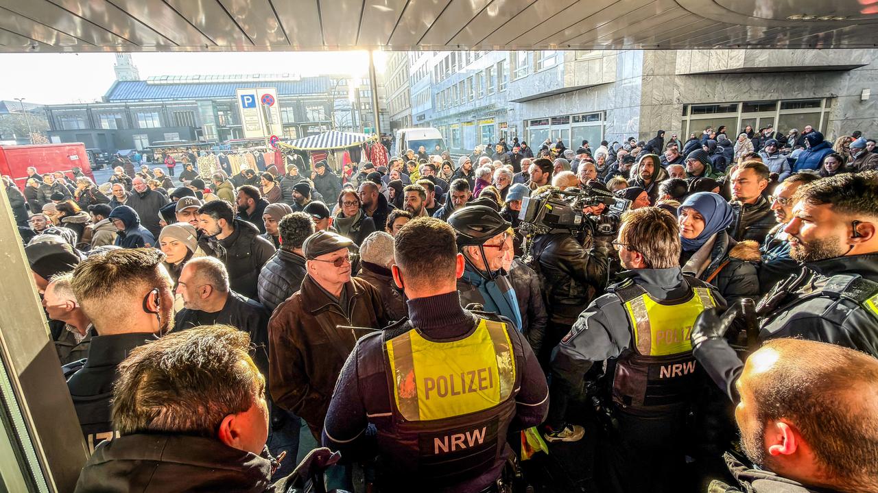 Policemen and concerned bank customers stand in front of a branch of the Sparkasse bank in Gelsenkirchen, western Germany, on Dec. 30, 2025. ( dpa / AFP Photo)