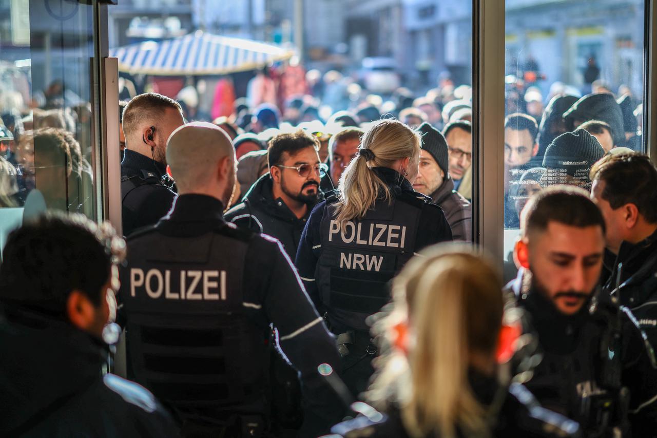 Policemen and concerned bank customers stand in front of a branch of the Sparkasse bank in Gelsenkirchen, western Germany, on Dec. 30, 2025. (AFP Photo)