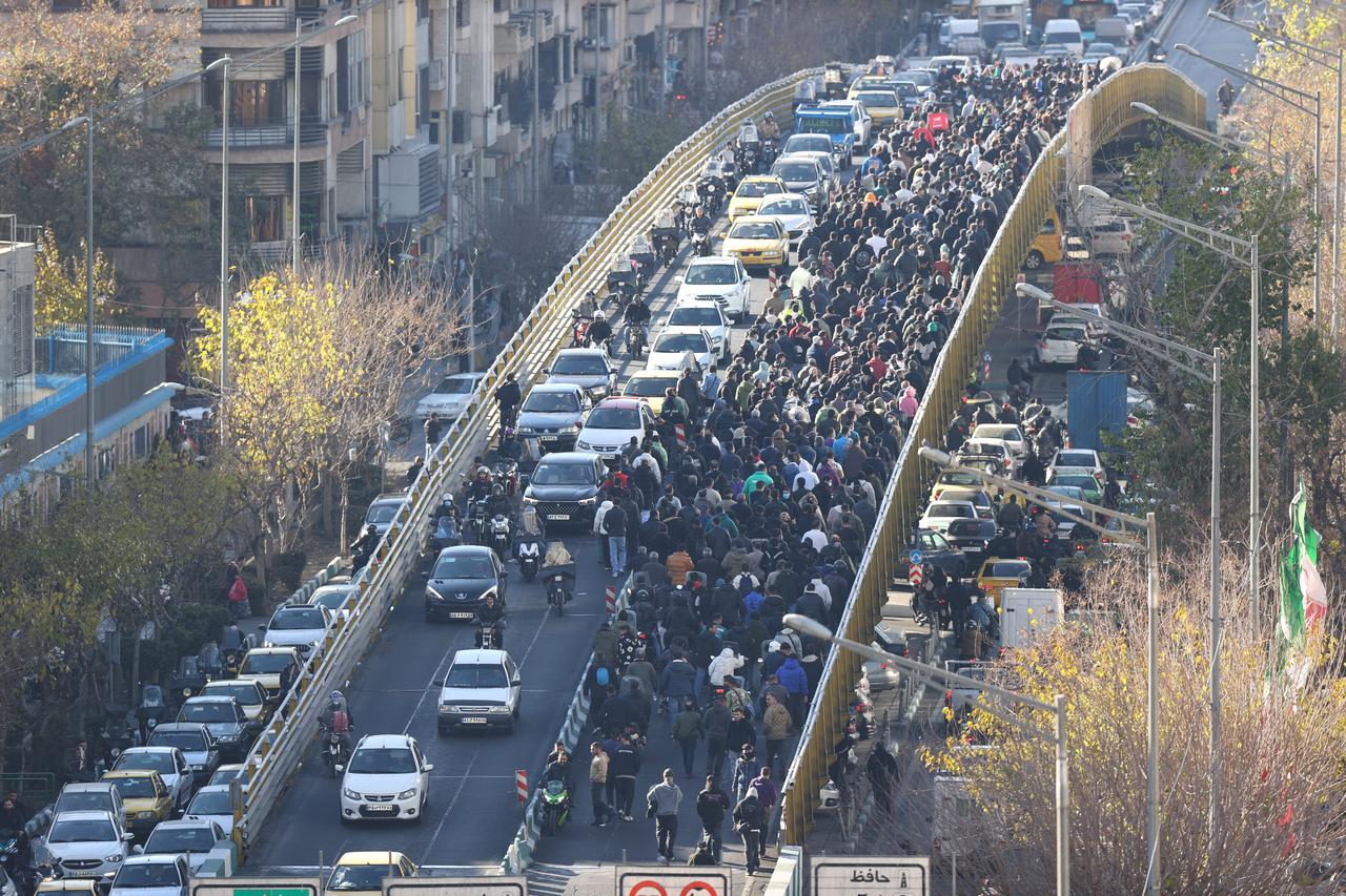 Shopkeepers and traders walk over a bridge during a protest against the economic conditions and Iran's embattled currency in Tehran on Dec. 29, 2025. (AFP Photo)