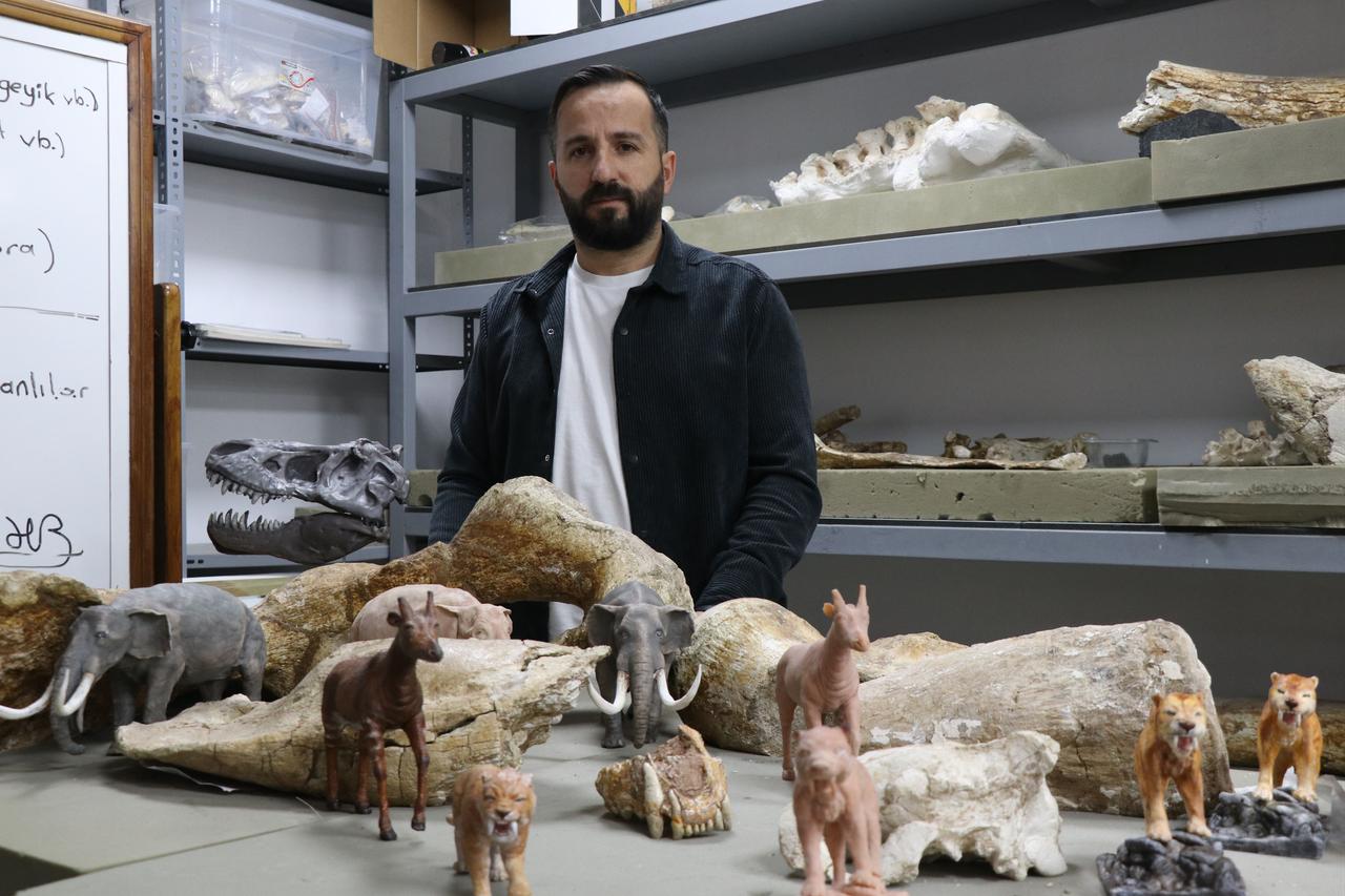 Miniature replicas of ancient megafauna, including elephants, giraffes and saber-toothed cats, are displayed alongside original fossil remains during preparation work at the Kayseri Metropolitan Municipality Science Center in central Türkiye, Jan. 19, 2026. (AA Photo)