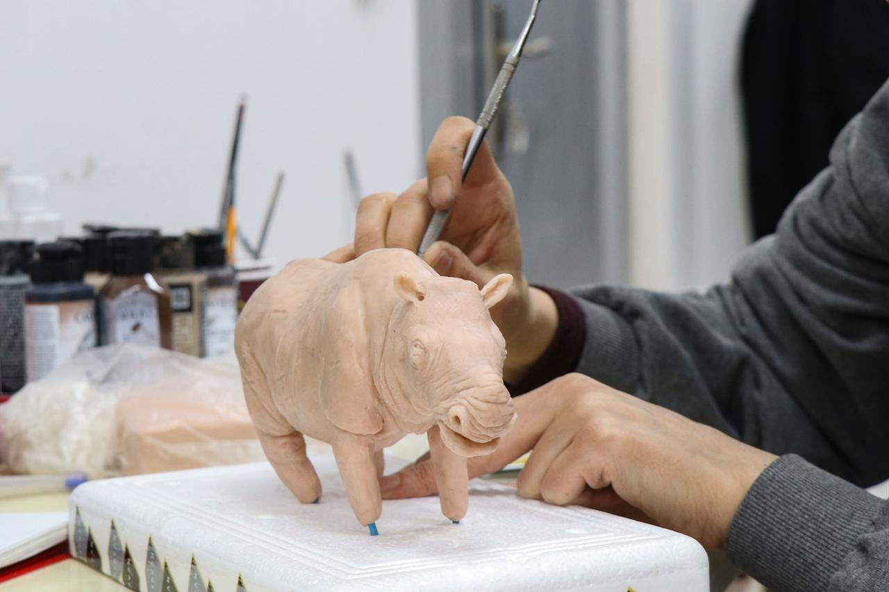 An artist shapes a small-scale model of an ancient rhinoceros using polymer clay, a key step before the figure is scanned and reproduced with 3D printing technology for museum display, Jan. 19, 2026. (AA Photo)