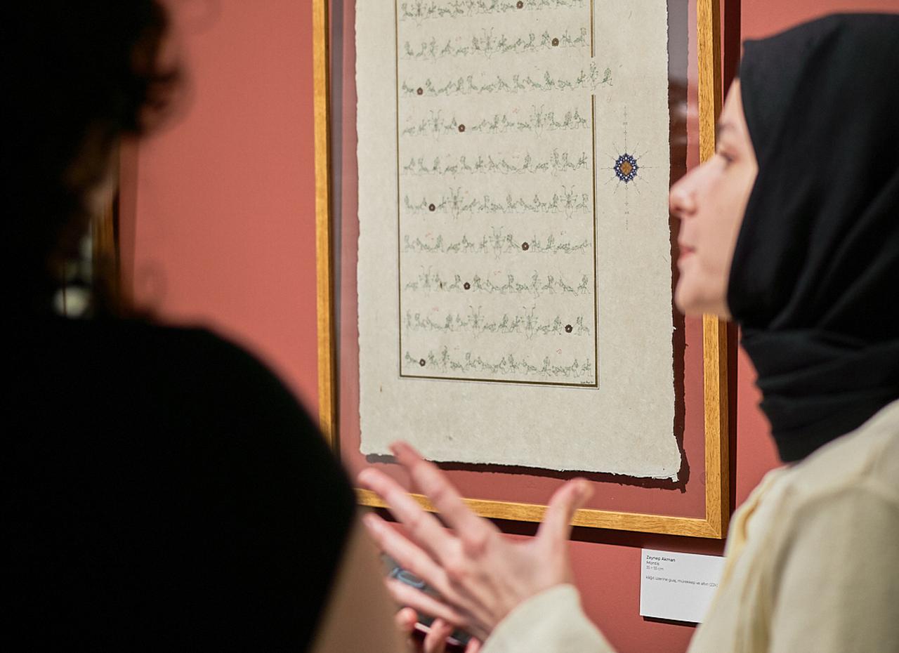 Visitors discuss a calligraphy-based artwork exhibited at Black Light Gallery during the gallery’s inaugural exhibition, “Gelenek: In Progress,” in Karakoy, Istanbul, Türkiye, Jan. 19, 2026. (AA Photo)