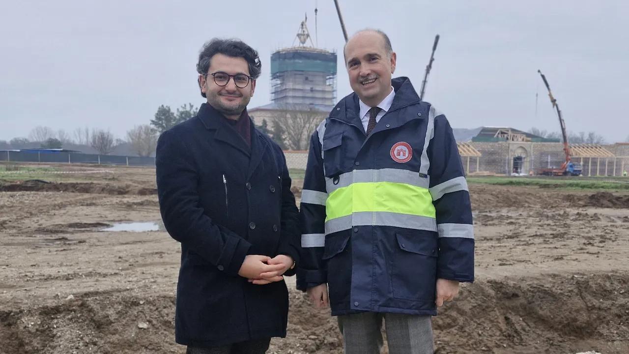 Journalist Murat Oztekin poses with National Palaces President Yasin Yildiz at the Edirne Palace site, as cranes and scaffolding rise behind them during the ongoing revival works. (Photo via Türkiye daily)