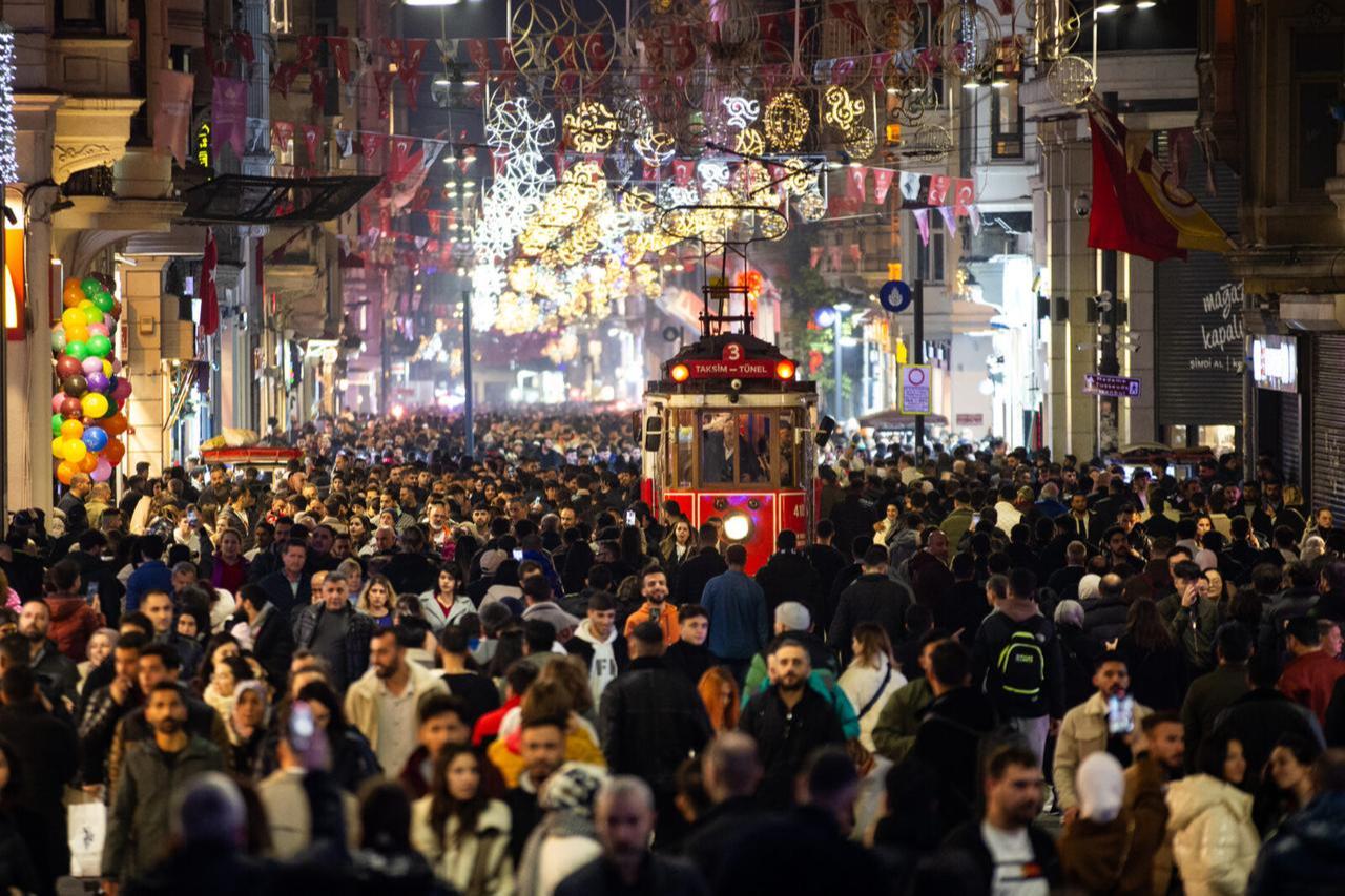 A bustling evening on Istiklal Avenue in Istanbul, as crowds enjoy the lively atmosphere and iconic red tram during winter, Türkiye, Dec.31, 2023. (AA Photo)
