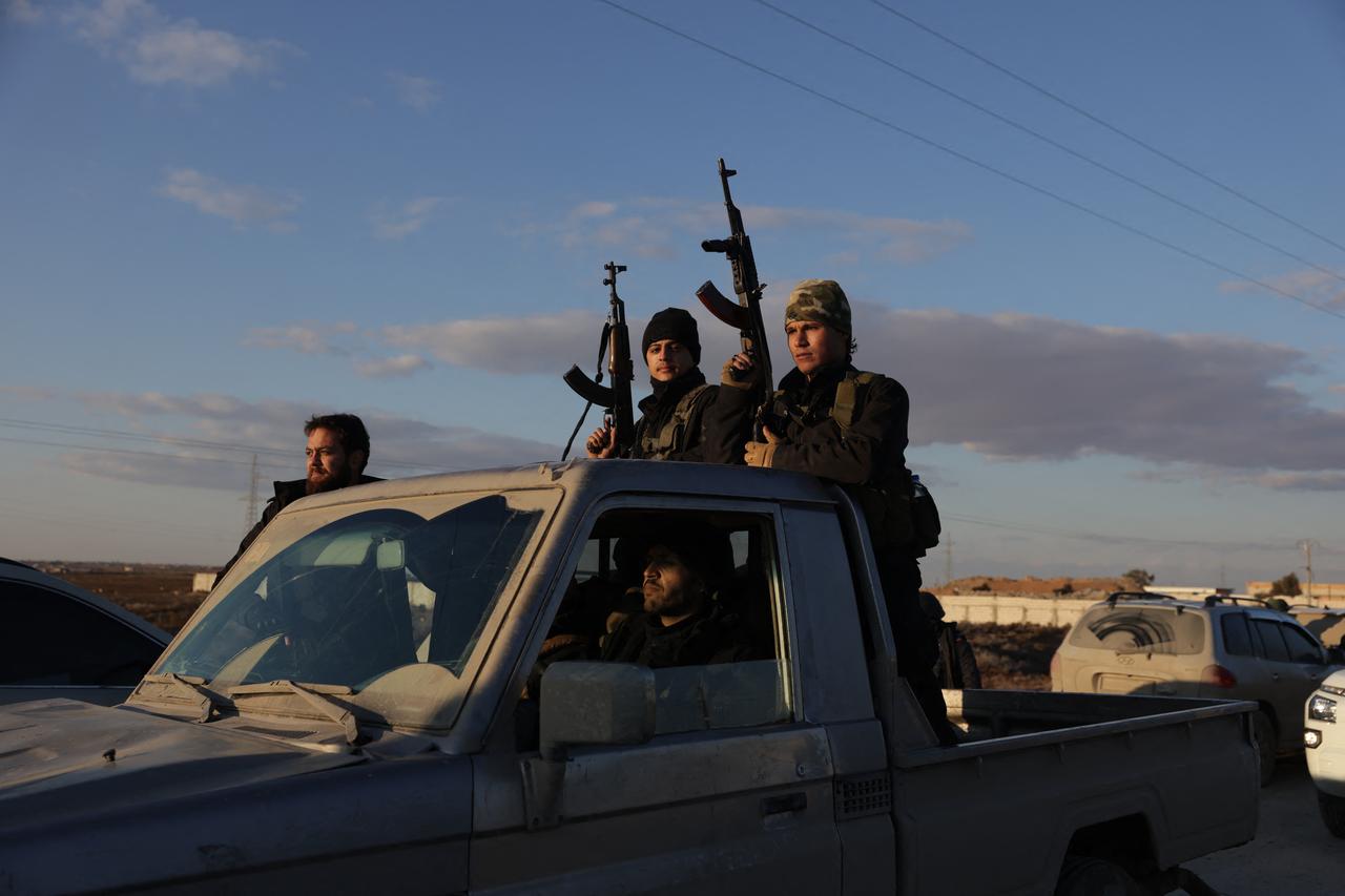 Syrian government forces brandish their weapons as they take possession of the SDF military base as they enter the city of Raqqa, Syria on January 19, 2026. (AFP Photo)