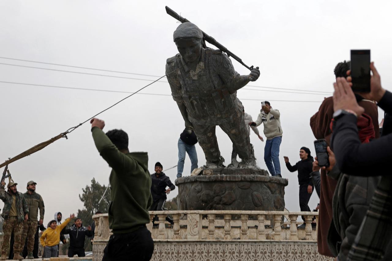 Local residents bring down a pro-YPG/SDF statue after the withdrawl of SDF in Tabqa, in Raqqa, Syria, January 18, 2026. (AFP Photo)