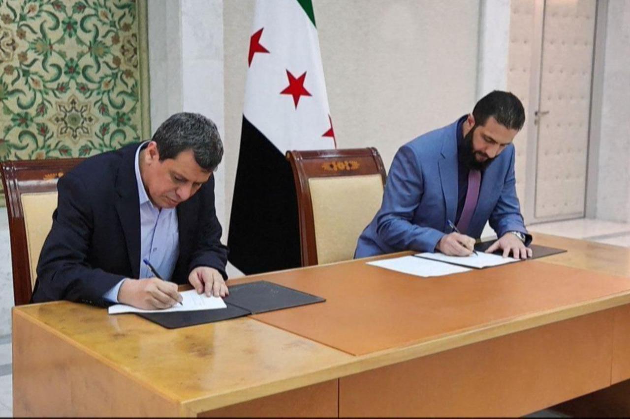 A SANA handout photo shows Syrian President Ahmed al-Sharaa and Mazloum Abdi, ringleader of the YPG-dominated SDF, signing a deal to fold SDF elements into the national government in Damascus, March 10, 2025. (AFP Photo)