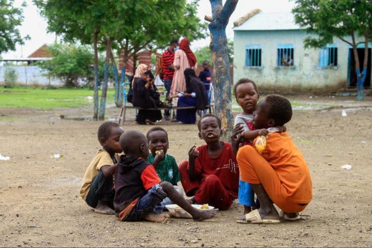 Displaced children share a meal provided through a charity initiative at a displacement camp in Gedaref city in the east of war-torn Sudan.  ( AFP Photo )