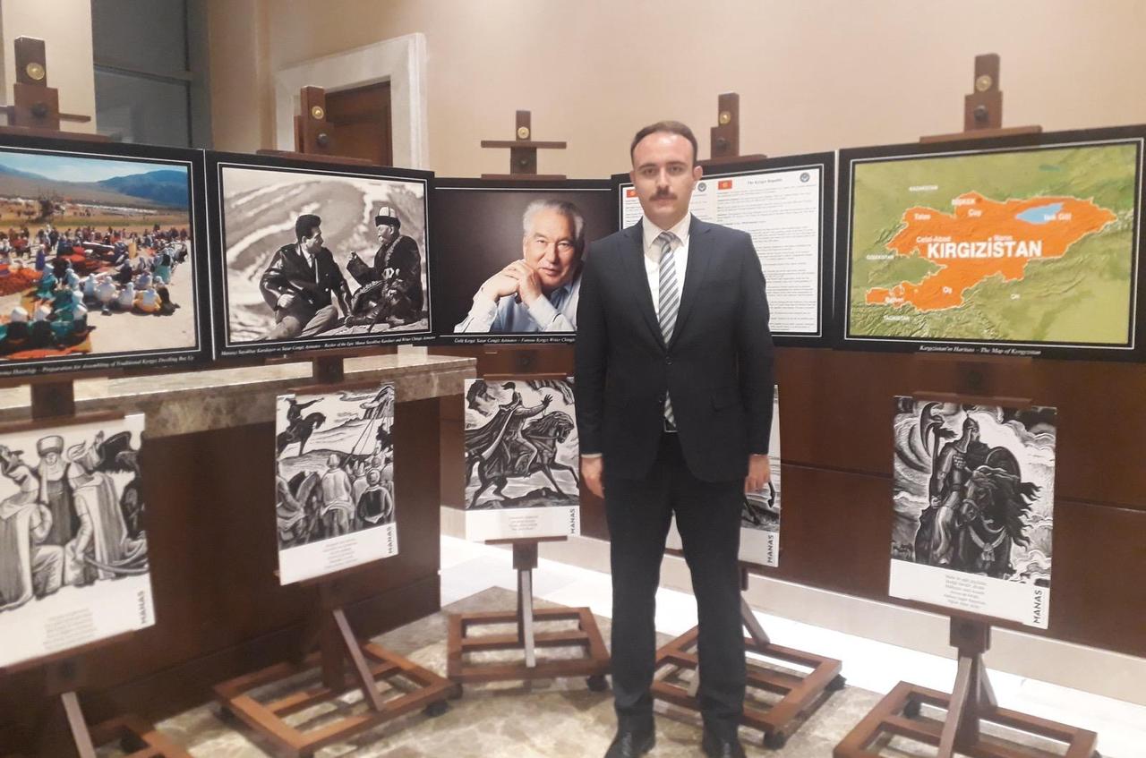 Umut Erdogan, a lecturer at Bolu Abant Izzet Baysal University, stands in front of an exhibition display featuring historical and cultural visuals related to the Turkic world, during an academic or cultural event highlighting shared heritage. (Photo via Türkiye Today's archive)