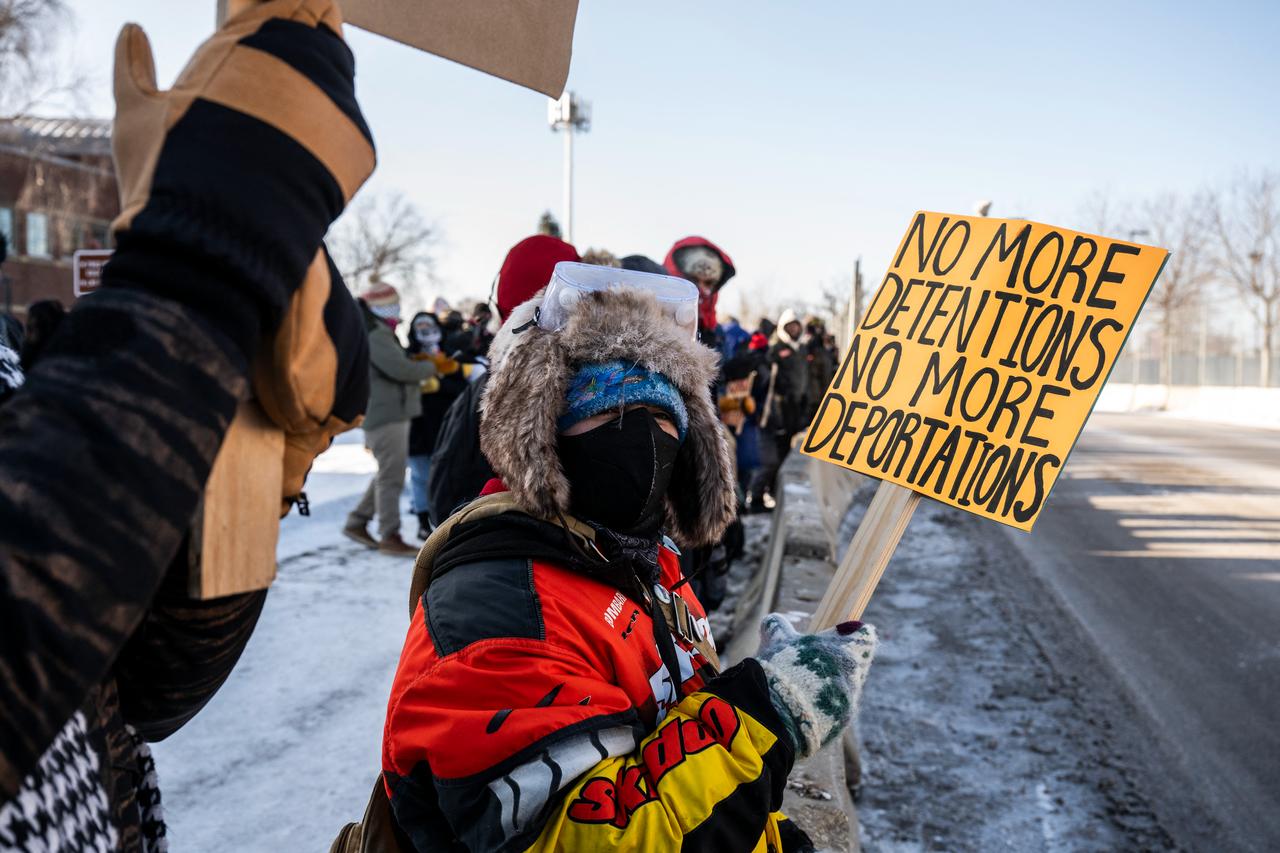 Protesters and activists hold signs as they watch ICE agents arrive in vehicles at the the Bishop Henry Whipple Federal Building as they participate in a “ICE out of Minnesota: Day of Truth and Freedom” in Minneapolis, Minnesota on Jan. 23, 2026. (AFP Photo)
