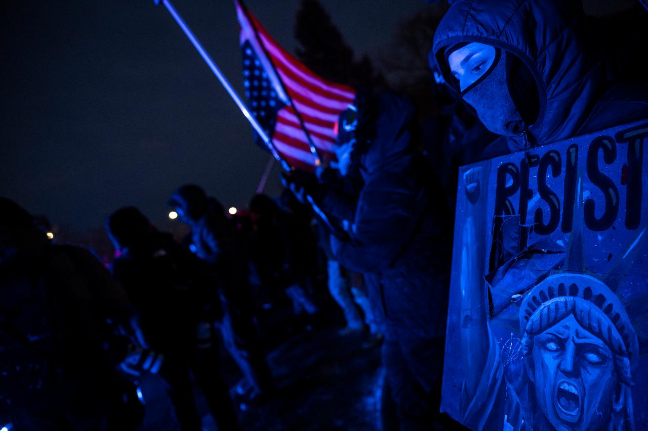 A protester with their face covered holds a poster during an anti-US Immigration and Customs Enforcement (ICE) protest in front of the Bishop Henry Whipple Federal Building in Minneapolis, Minnesota on Jan. 17, 2026. (AFP Photo)