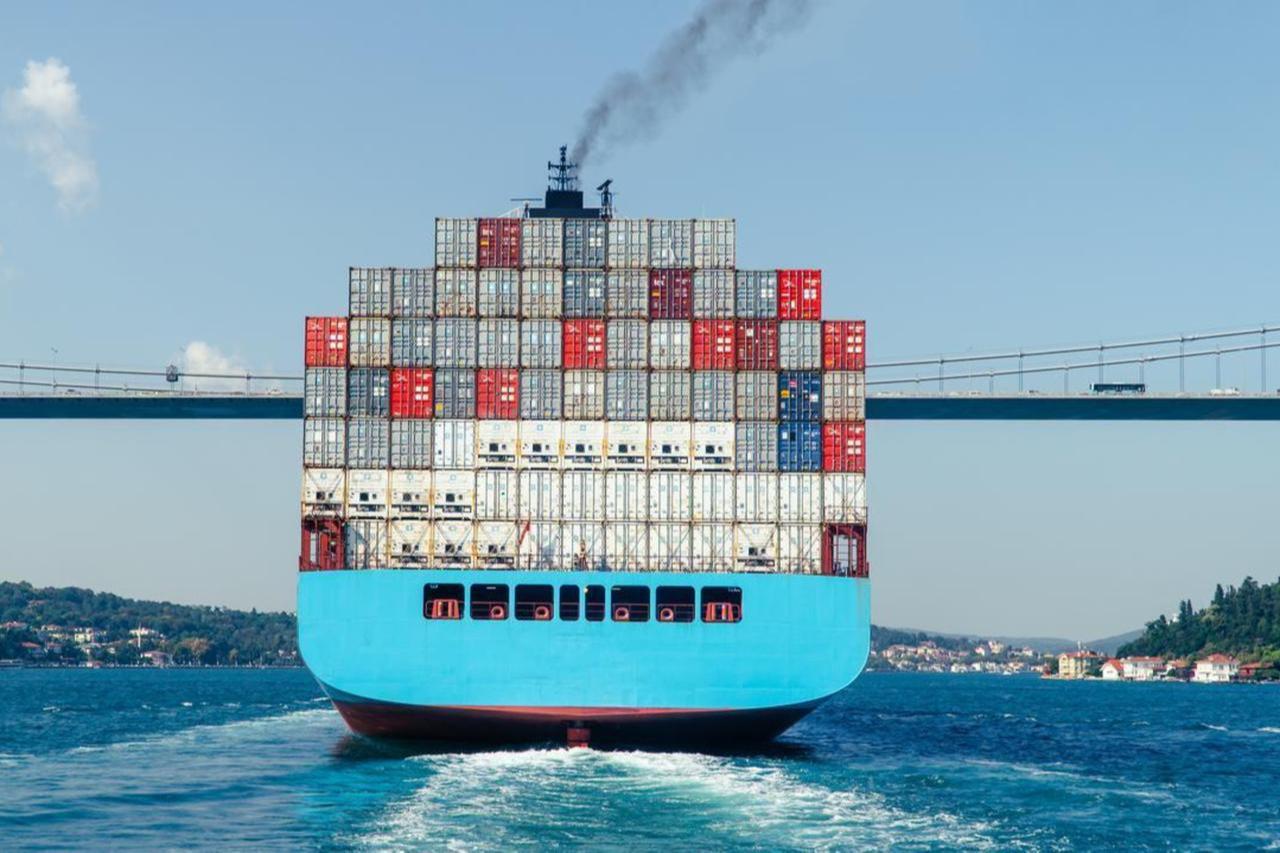 Rear view of a fully loaded container ship passing beneath the Fatih Sultan Mehmet Bridge on the Bosporus Strait in Istanbul, Türkiye. (Adobe Stock Photo)