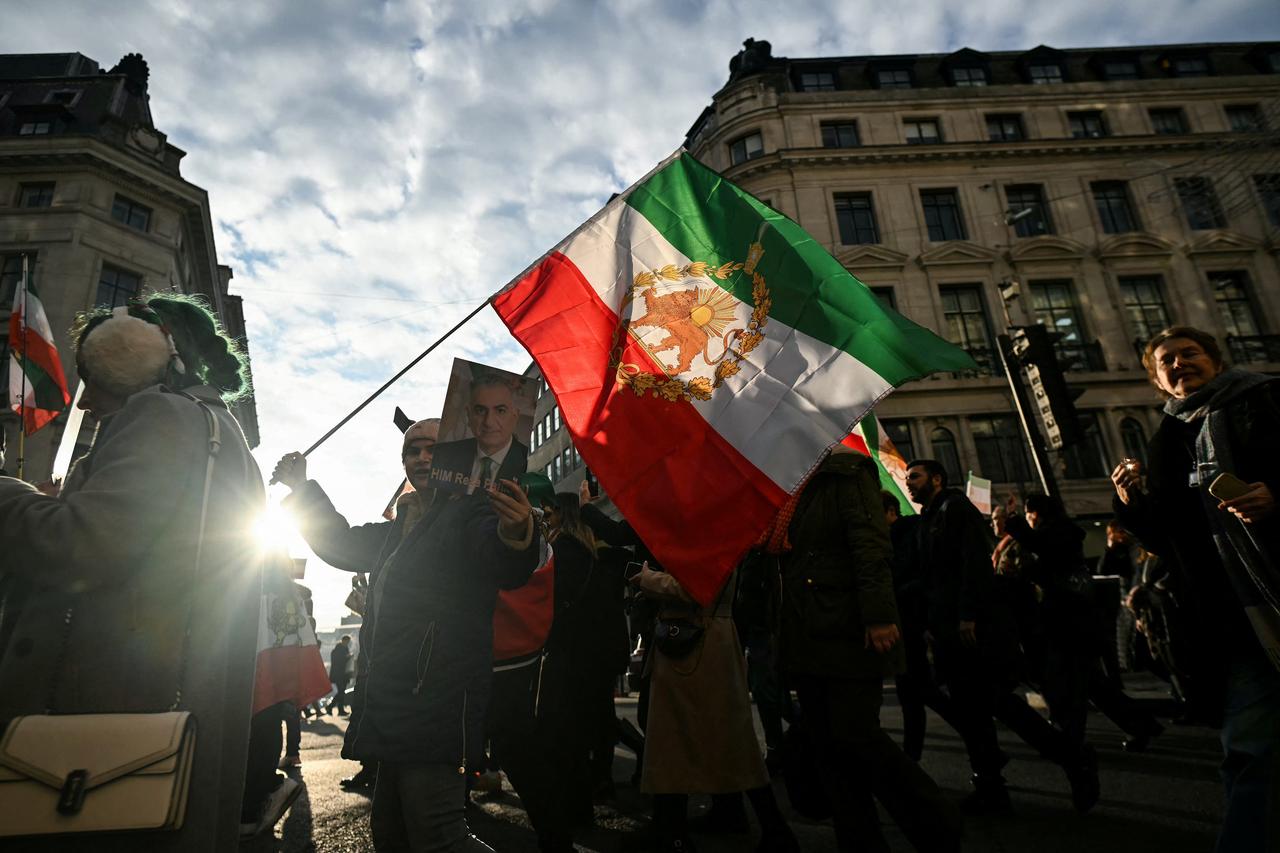 Protesters hold placards and Iran pre-1979 Revolution flags as they take part in a march to Downing Street against Iran's crackdown on protesters, in London, UK on January 18, 2026. (AFP Photo)