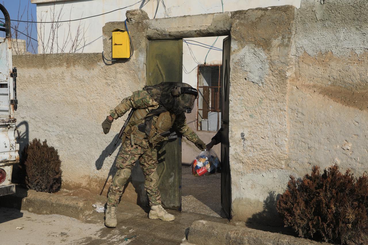 Syrian army forces distribute food aid packages to local residents in the town of Sarrin, in the Manbij district of Aleppo province, January 25, 2026. (AA Photo)