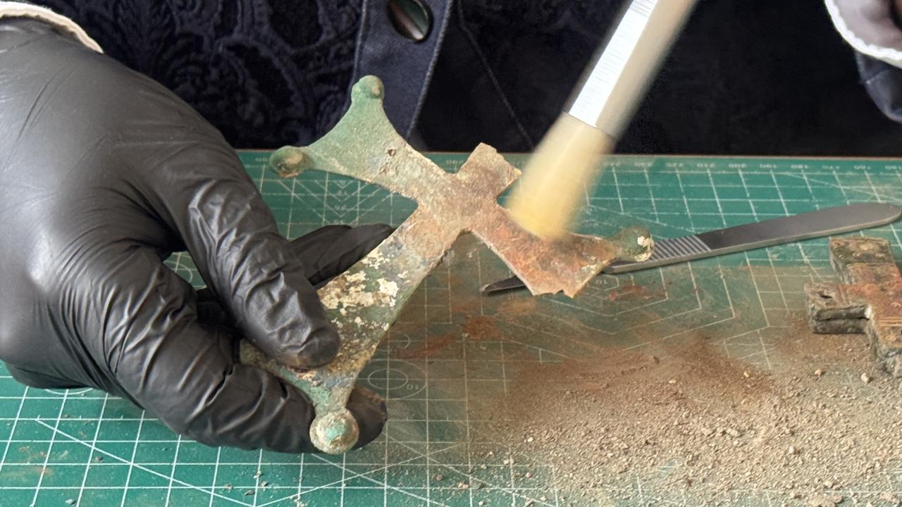 The restored bronze cross, decorated with geometric motifs and riveted shut, is seen during conservation work at the Lystra excavation site in Konya, central Türkiye, Jan. 27, 2026. (AA Photo)