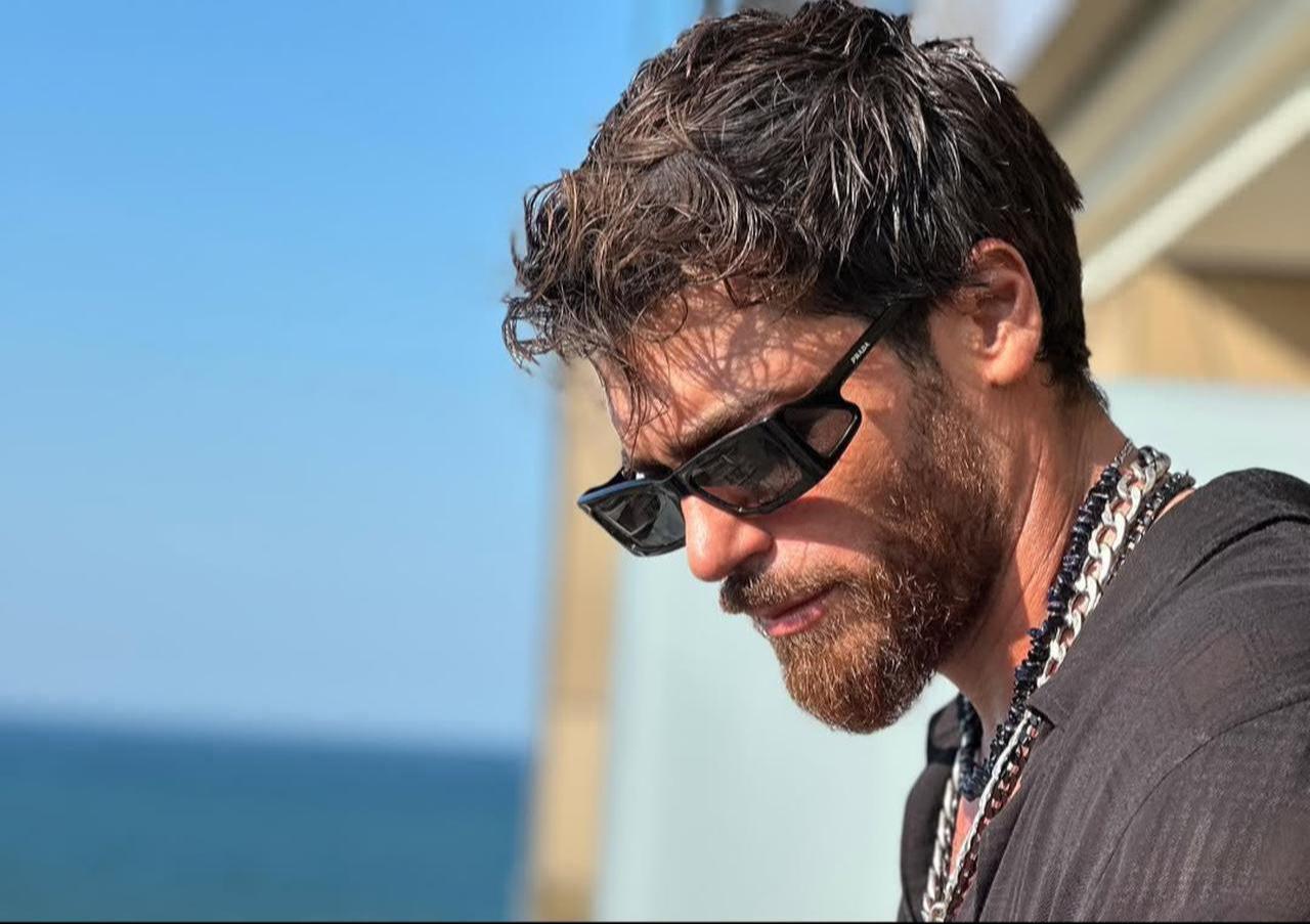 Can Yaman photographed on a balcony overlooking the sea, sharing a relaxed summer moment, on June 26, 2025. (Photo via Instagram/@canyaman)