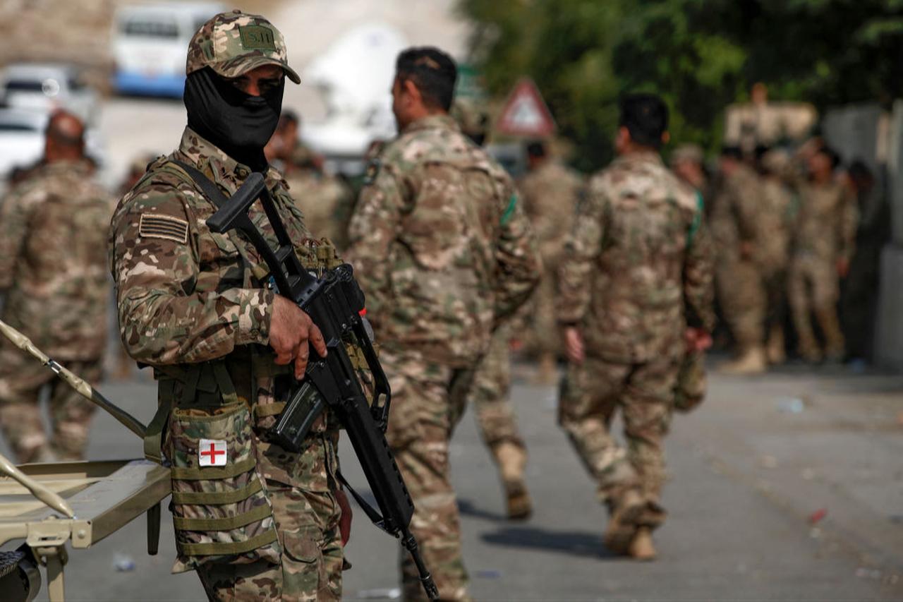A member of the Kurdish Peshmerga security forces stands guard as others head to a polling station to vote, ahead of the October 20 parliamentary election in the northern Iraqi city of Suleimaniyah on October 18, 2024. (AFP Photo)