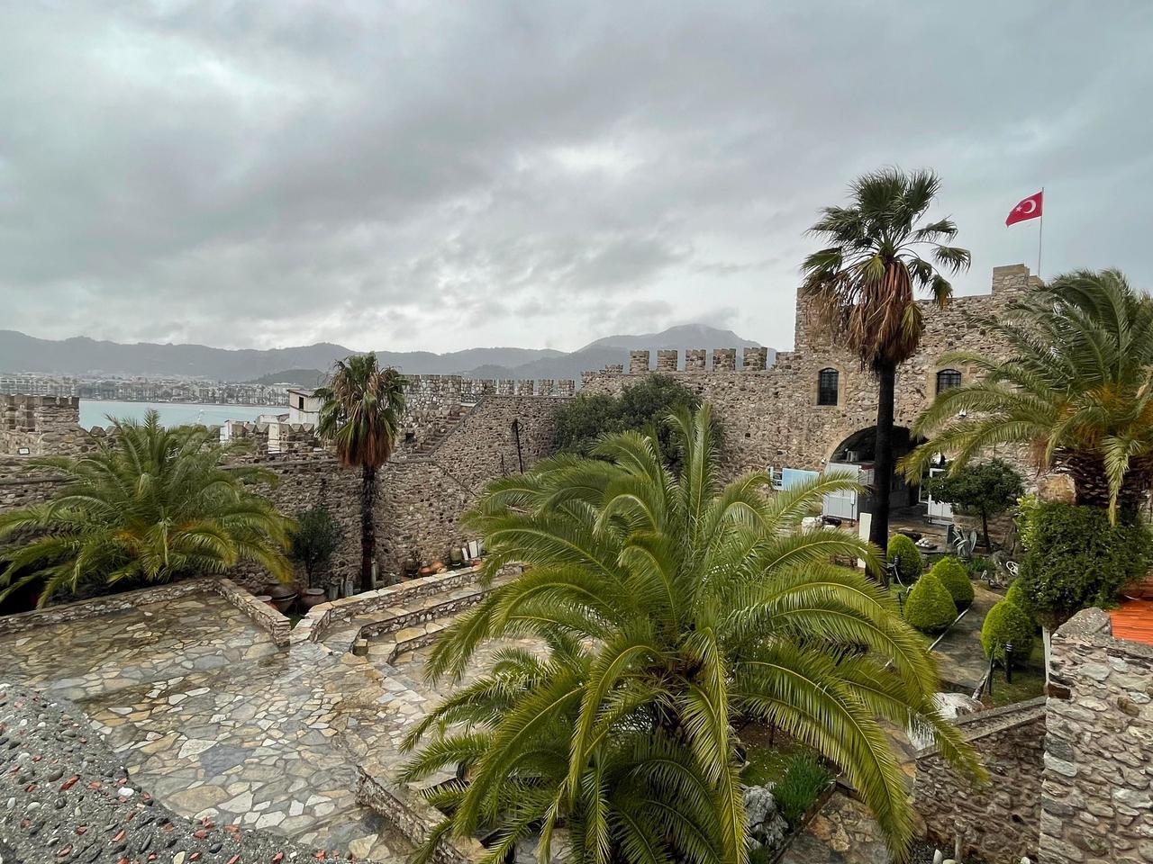 A general view of Marmaris Castle courtyard, where stone terraces and palm trees frame the open-air exhibition area of Marmaris Museum in Mugla, Türkiye, Jan. 27, 2026. (Photo by Koray Erdogan/Türkiye Today)