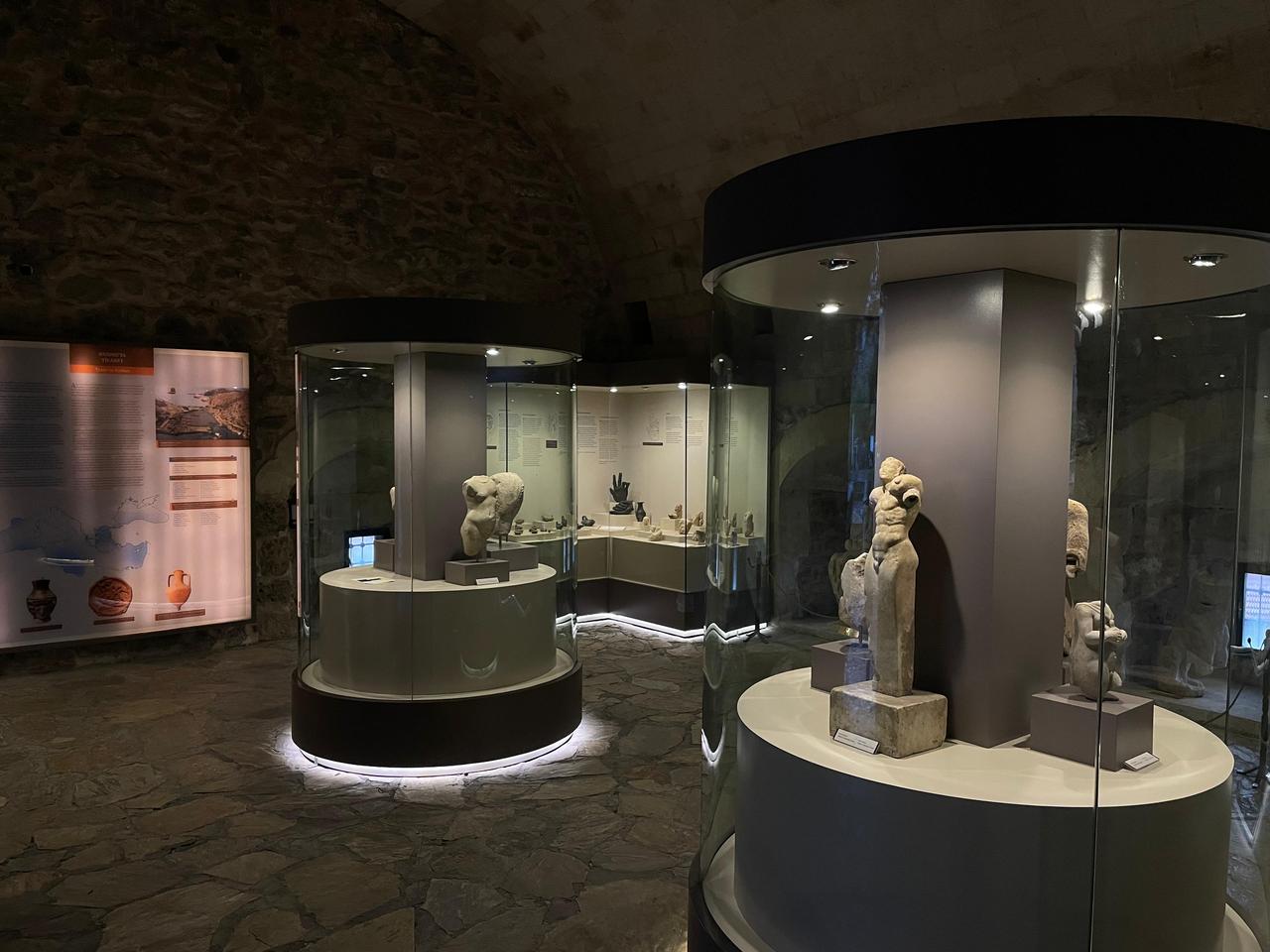 Statues and sculptural fragments displayed inside a vaulted exhibition hall of Marmaris Museum, where modern showcases are set against the historic stone interior of Marmaris Castle in Mugla, Türkiye, Jan. 27, 2026. (Photo by Koray Erdogan/Türkiye Today)