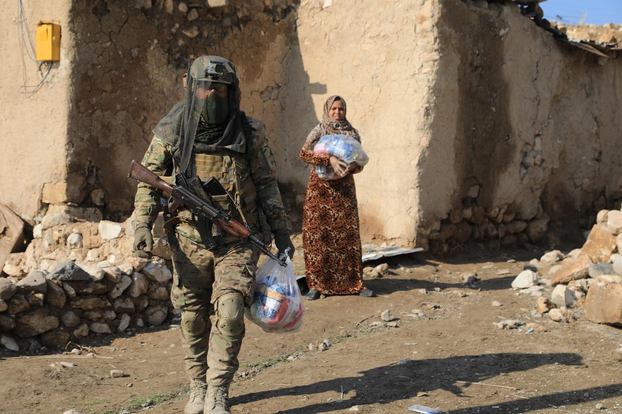 Syrian army forces distributes food aid packages to local residents in the town of Sarrin, in the Manbij district of Aleppo province, after the area was cleared of the YPG, operating under the name SDF, on Jan. 25, 2026. (AA Photo)