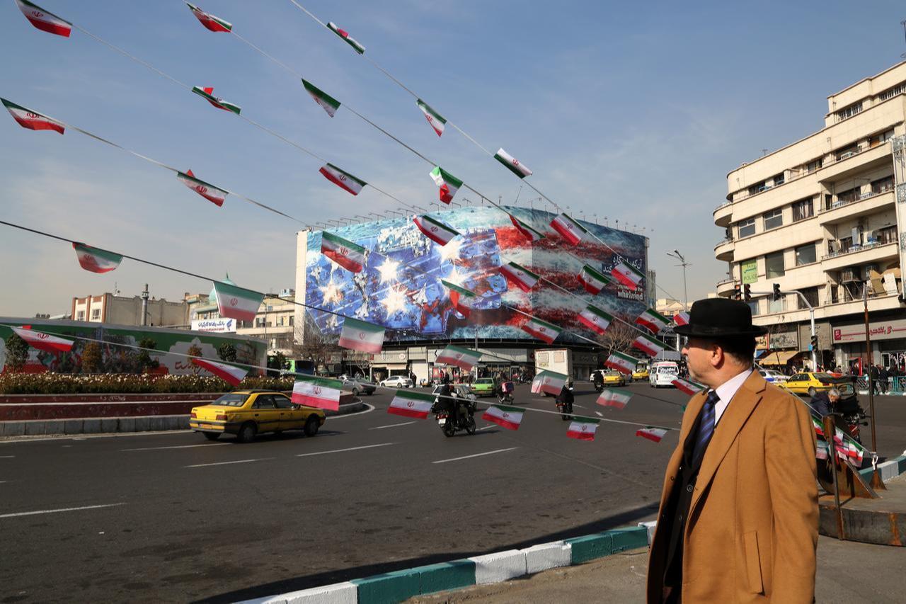 A man looks at the anti-American posters and Iranian flags displayed following a possible US intervention against Iran, Jan. 28, 2026, in Tehran, Iran. (AA Photo)