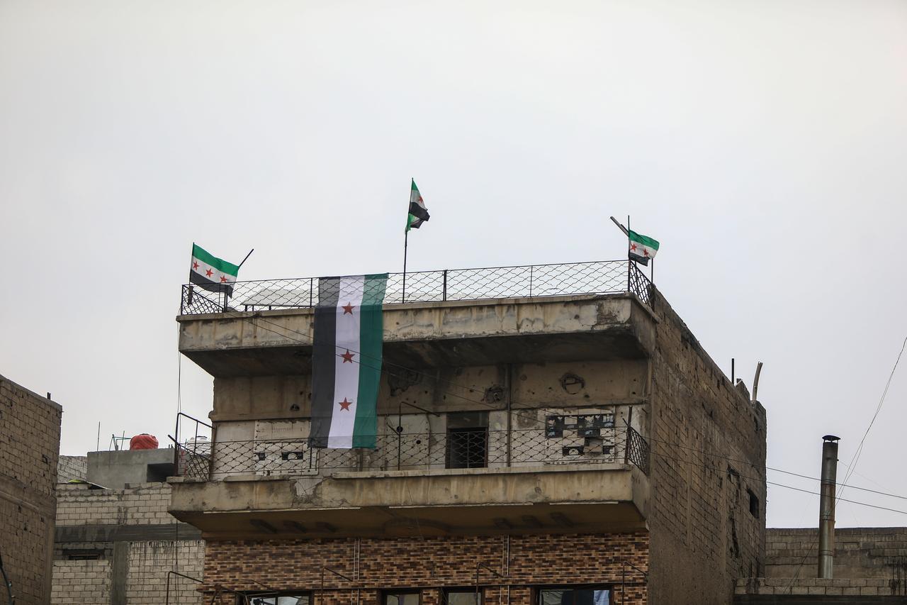 The three-star Syrian flag is seen hanging from buildings in Raqqa's city center, Syria, on January 28, 2026. (AA Photo)