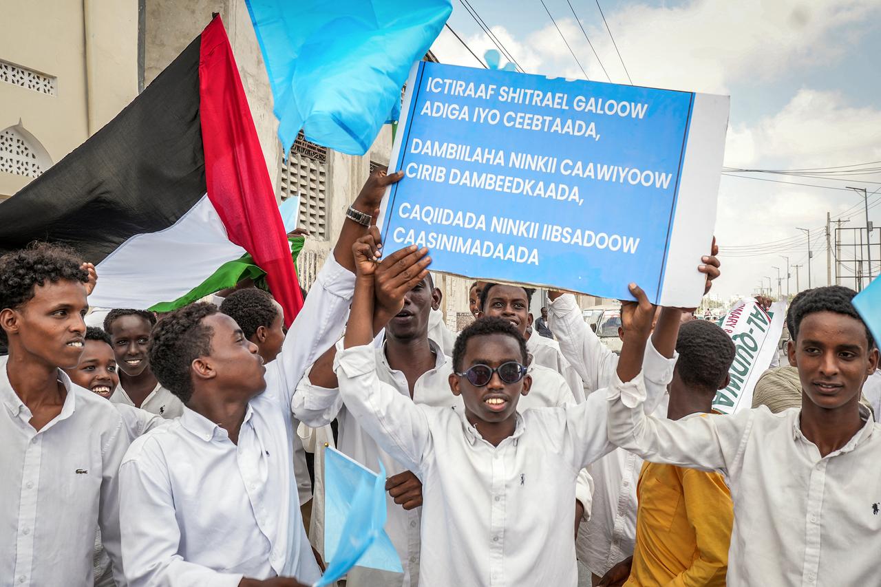 Residents wave Somali and Palestinian flags and hold placards at Mogadishu Stadium in Mogadishu on December 30, 2025. (AFP Photo)