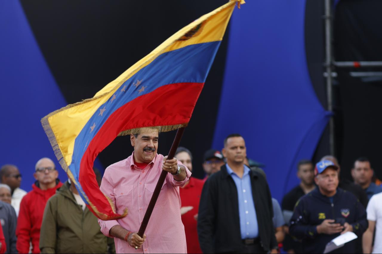Venezuelan President Nicolas Maduro waves a Venezuelan flag during a march to swear in the Bolivarian Grassroots Committees in Caracas, Venezuela, Nov. 15, 2025. (AA Photo)