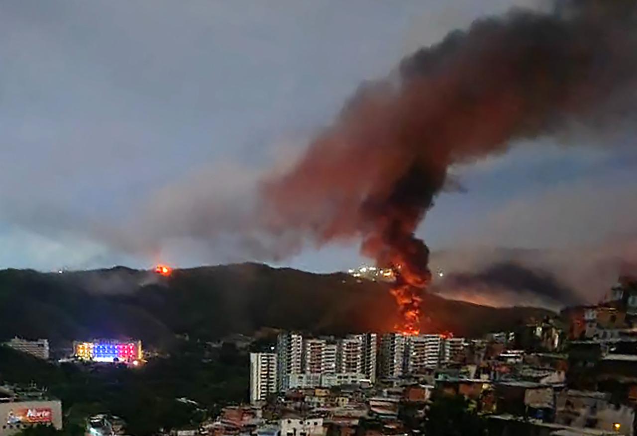 Fire at Fuerte Tiuna, Venezuela's largest military complex, is seen from a distance after a series of explosions in Caracas on January 3, 2026. (AFP Photo)