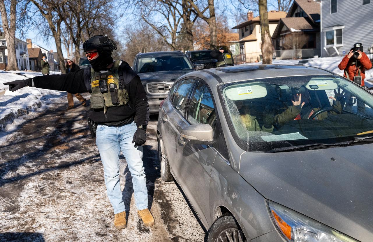 A member of the U.S. Border Patrol directs people to move to the sidewalk as they confront people in a vehicle that was following them, Minneapolis, Minnesota, United States, January 29, 2026. (AFP Photo)