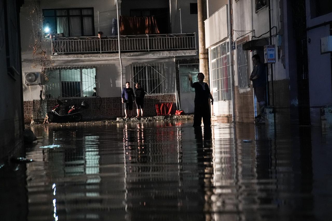 Residents stand outside their flooded homes as severe rainstorms inundate streets across central districts of Izmir, Türkiye on Jan. 29, 2026. (AA Photo)