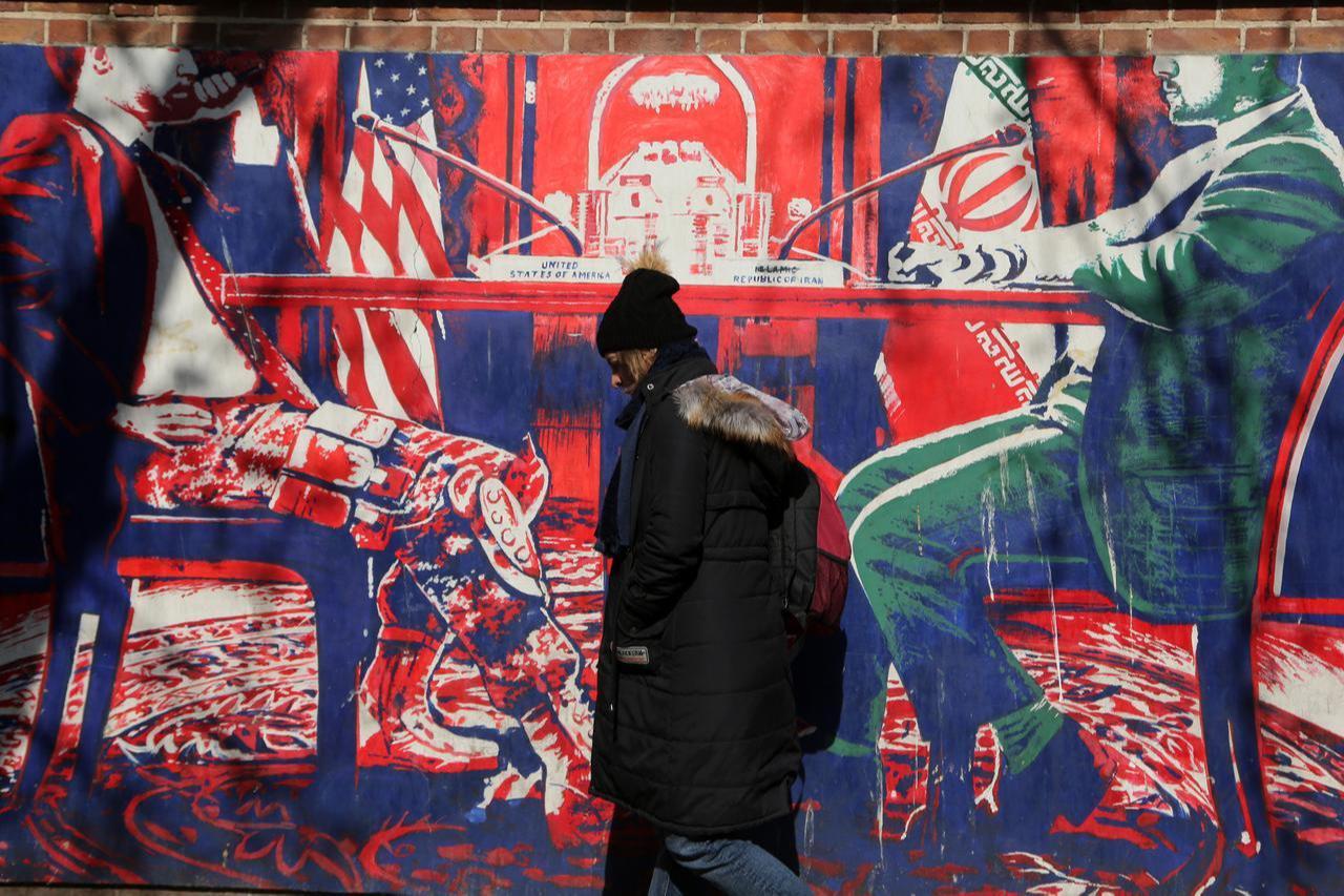A woman walks past an anti-American mural following a possible US intervention against Iran on January 28, 2026, in Tehran, Iran. (AA Photo)