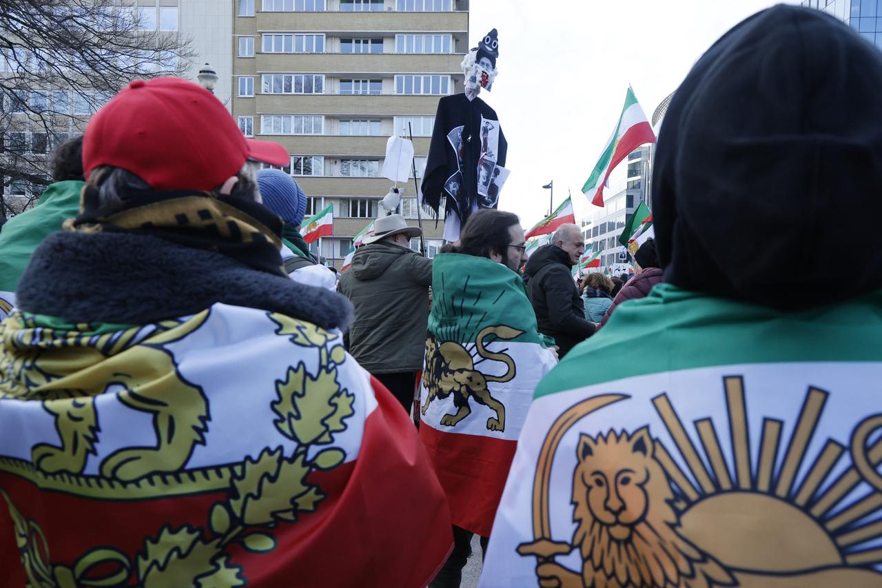 Protesters drapped in Iran flags with the Lion and Sun emblem attend a demonstration held by the Iranian diaspora in solidarity with protests currently taking place in Iran, at the European quarters of Brussels, Belgium on January 25, 2026. (AFP Photo)