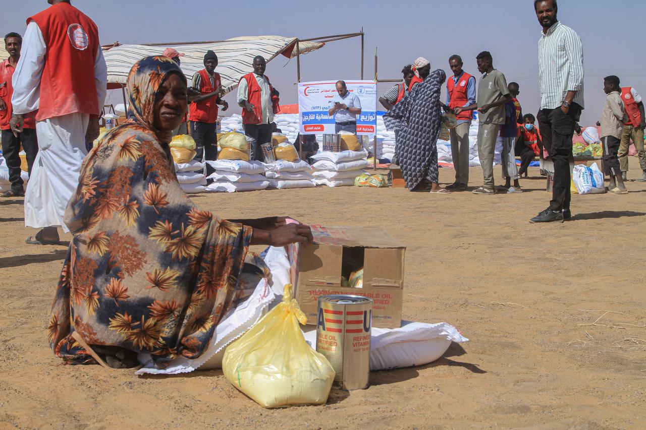 A Sudanese womeann who fled El-Fasher sits next aid she received at the Al-Afad camp for displaced people in the town of Al-Dabba, northern Sudan, on November 25, 2025. ( AFP Photo )