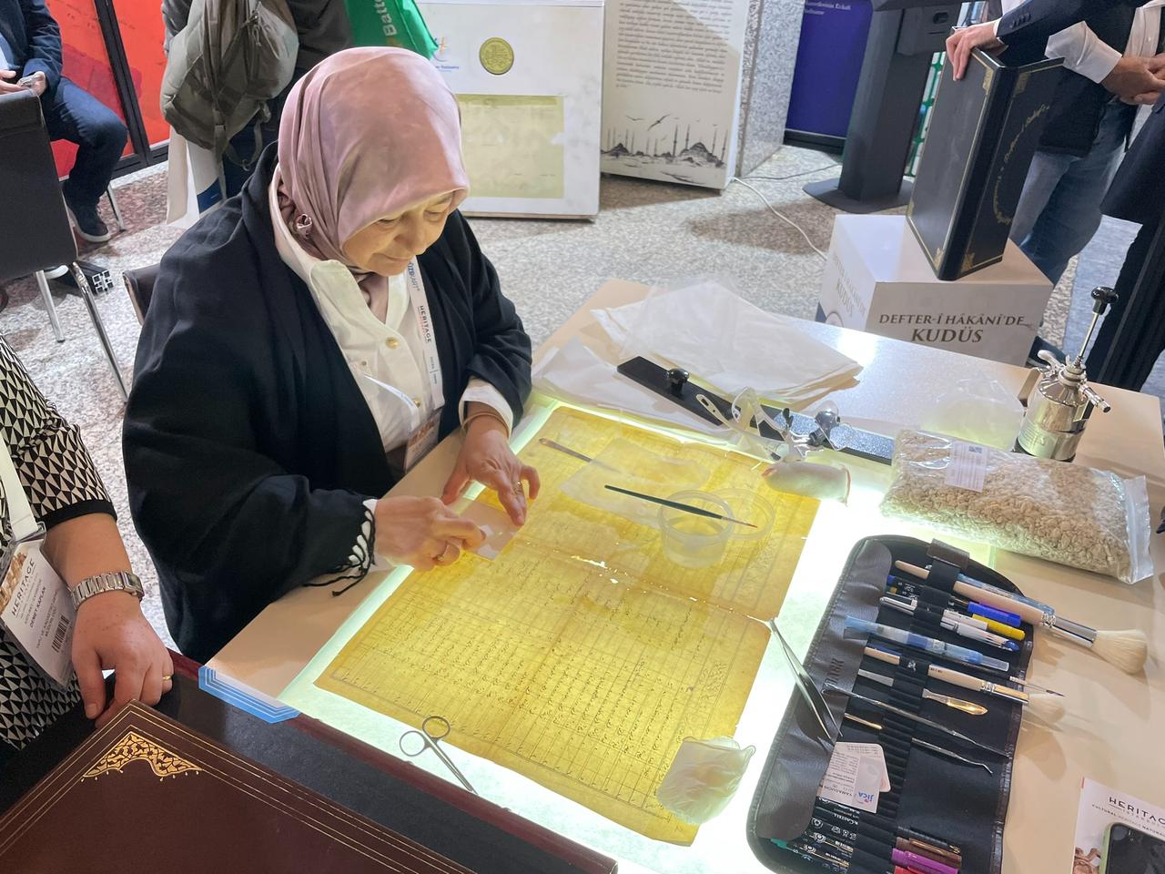 A conservation specialist demonstrates manuscript restoration techniques during Heritage Istanbul 2024 at the Istanbul Lutfi Kirdar Convention and Exhibition Center, highlighting traditional craftsmanship and modern preservation methods used for historical documents, May 15, 2024. (Photo by Koray Erdogan/Türkiye Today)