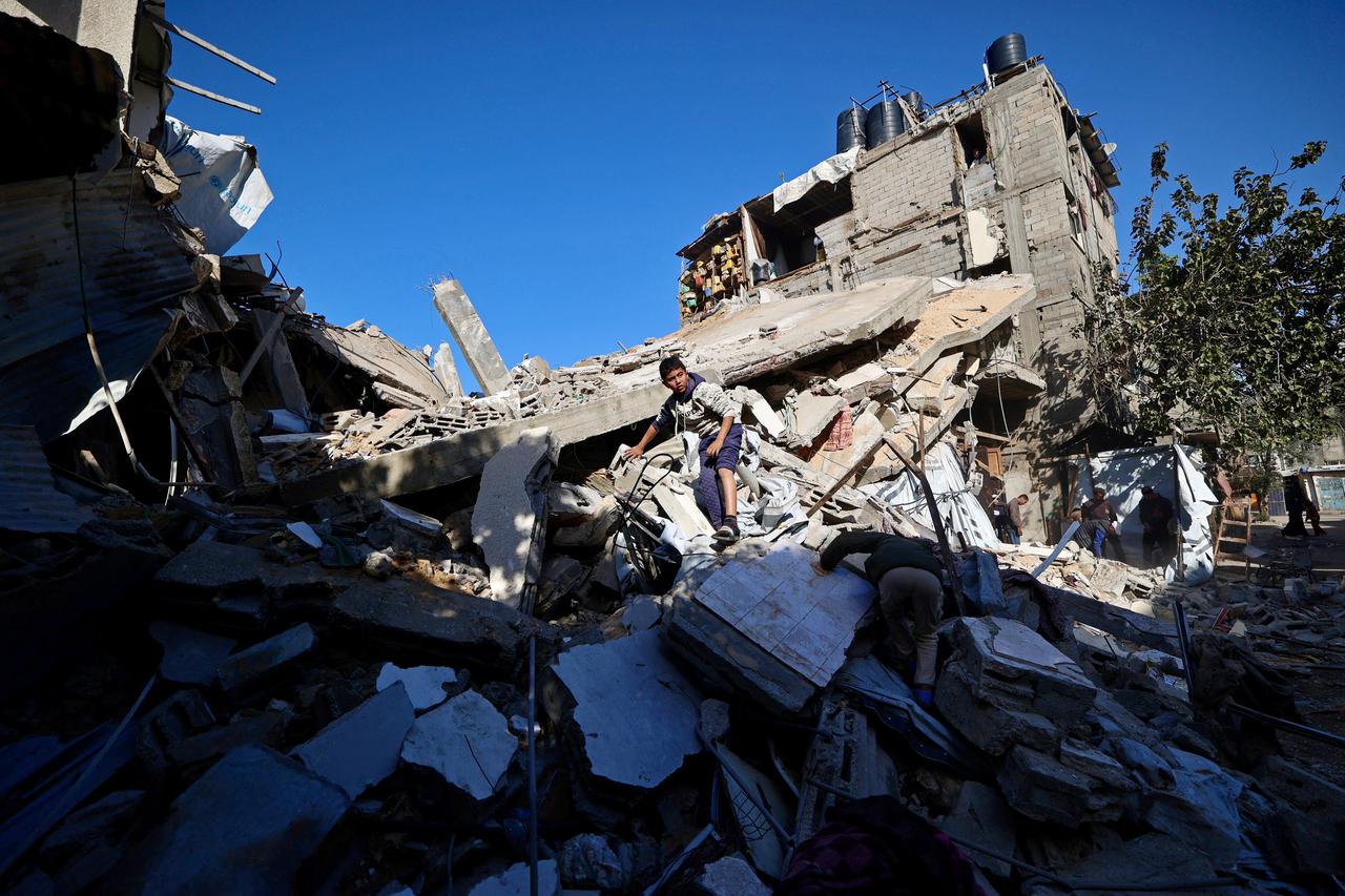 A Palestinian boy looks for his belongings amid the debris of a collapsed house that was previously damaged by an Israeli strike, at the Maghazi refugee camp in the central of Gaza Strip on Jan. 5, 2026. (AFP Photo)