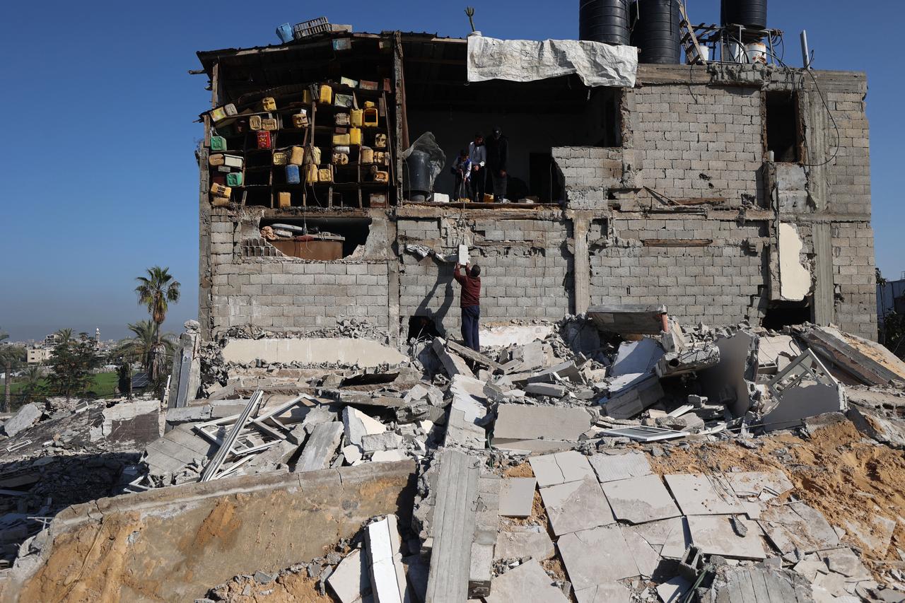 Palestinians look for their belongings amid the debris of a collapsed house that was previously damaged by an Israeli strike, at the Maghazi refugee camp in the central of Gaza Strip on Jan. 5, 2026. (AFP Photo)